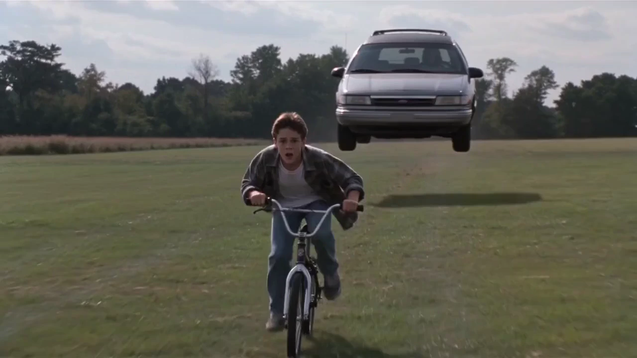 Shot 1 Subject: A teenage boy on a BMX bike wearing 90’s clothes riding through