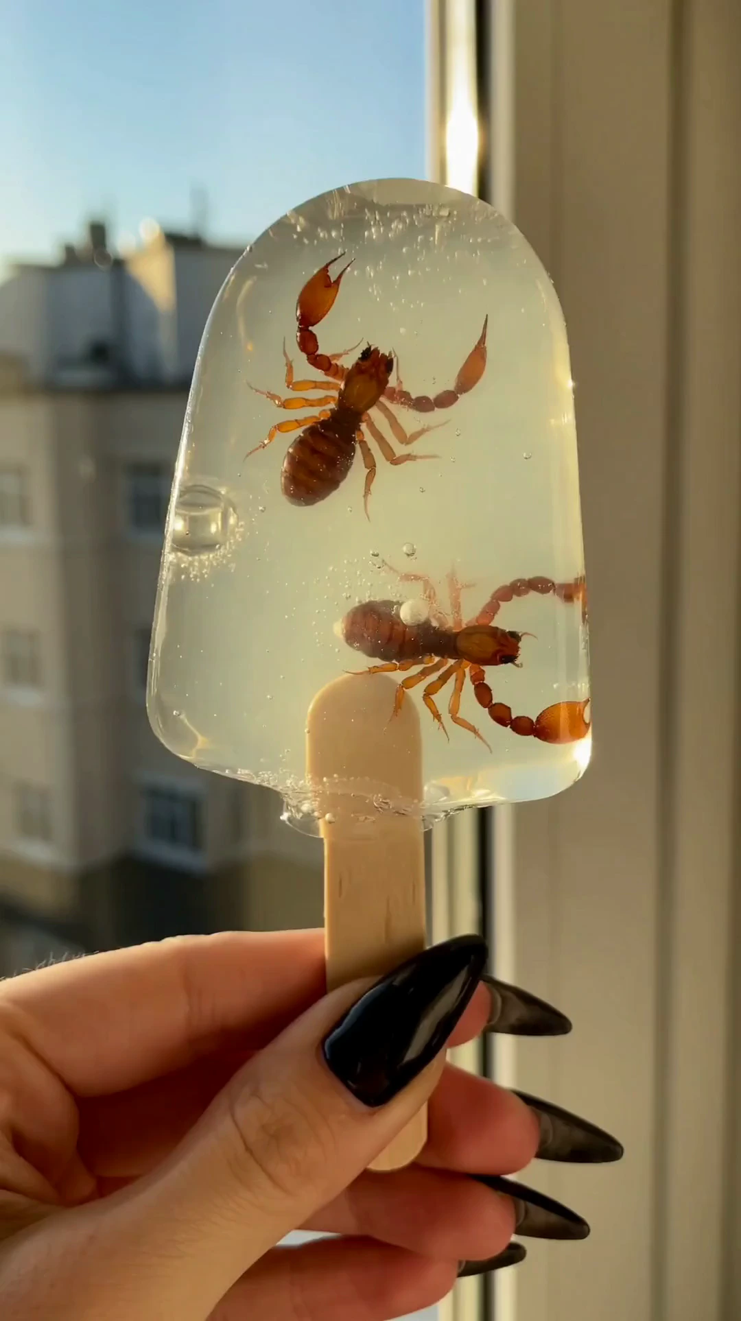A surreal cinematic macro shot of a transparent pale mint-green popsicle held